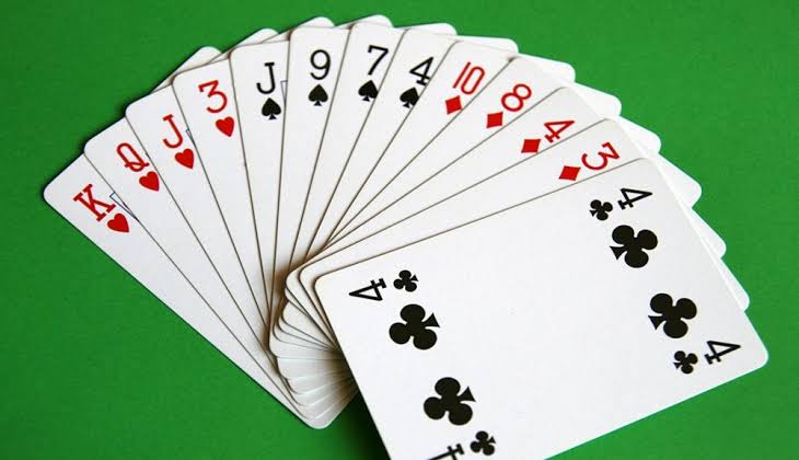 Cartas de baralho abertas sobre uma mesa verde