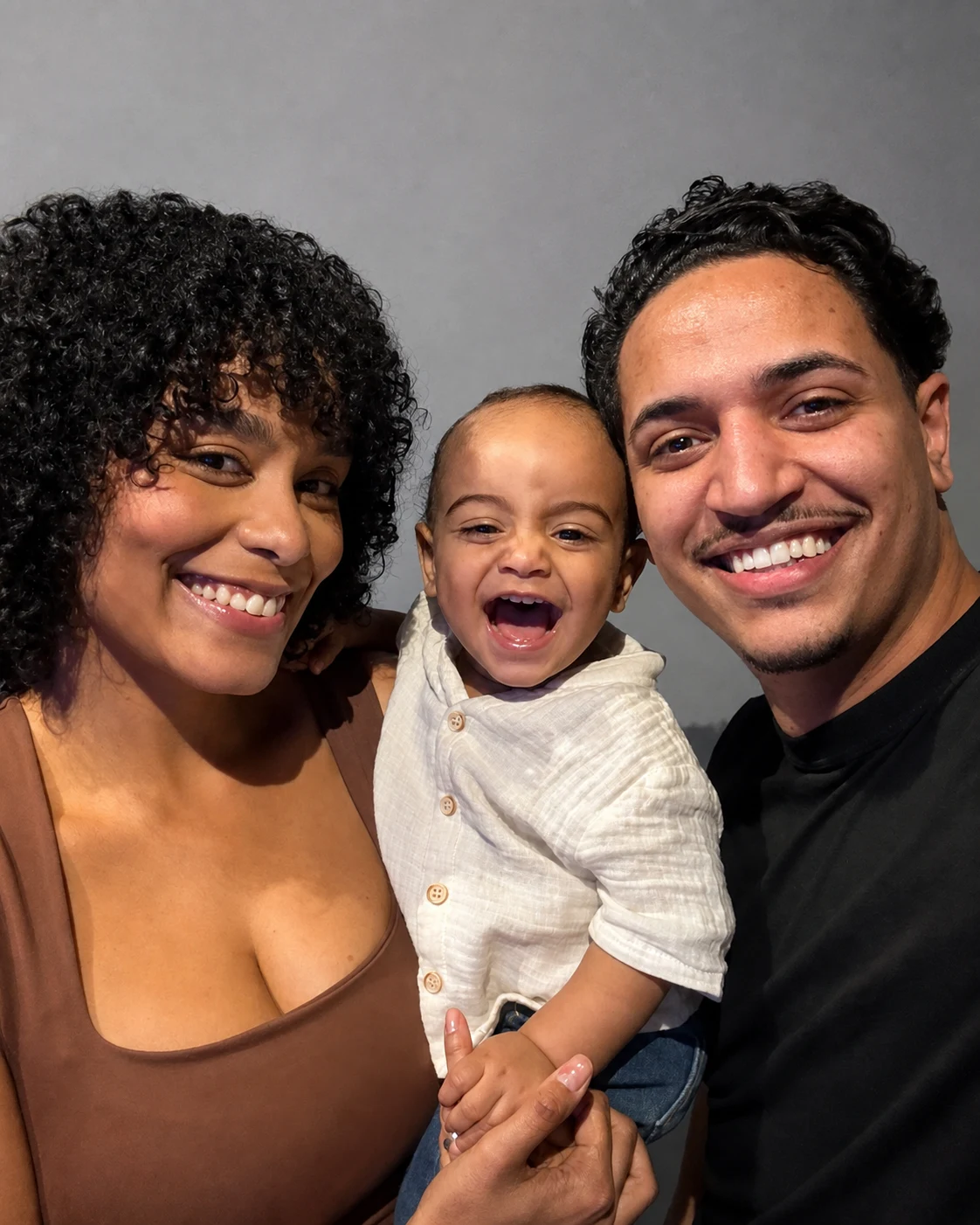Davi sorrindo entre seus pais